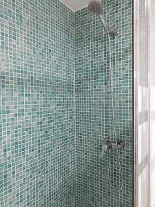 a bathroom with a shower with green tiled walls at Estudio Fenix LOS MOLINILLOS in Roquetas de Mar