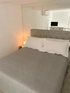 um quarto com uma cama com almofadas brancas em Palazzo Framì em Acireale