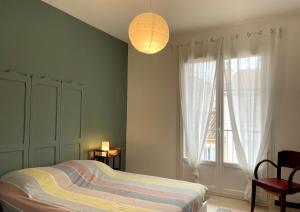 a bedroom with a bed and a lamp and a window at Hyper Centre Sanary 3 chambres parking balcon clim wifi in Sanary-sur-Mer