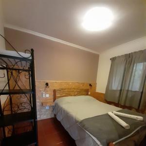 1 dormitorio con 2 camas, ventana y escalera en Casa da Vovó (Casa do Tapado), en Amarante