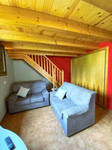 - un salon avec un canapé et un escalier dans l'établissement La Vall Apartaments Dúplex, à Sant Llorenc de Morunys