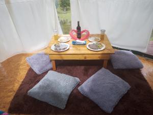 a table with plates of food and a bottle of wine at Glamping La Cacica in Guatavita