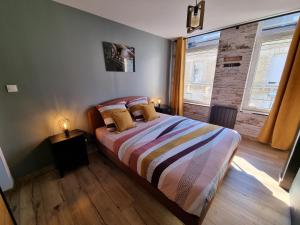a bedroom with a bed with two pillows on it at comme un air de chez soi in Calais
