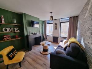 a living room with a couch and a table at comme un air de chez soi in Calais