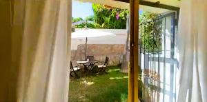 an open door to a patio with a table and an umbrella at VILLA Bed and Breakfast - kitchen, Pool, Barbecue and Large garden in Benidorm