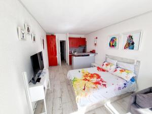 a bedroom with a bed and a kitchen with red cabinets at Cap Capistol Studio avec terrasse, vue port in Cap d'Agde