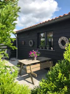 a picnic table with flowers on a patio at Chalet peter in Limmen