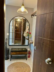 La salle de bains est pourvue d'un miroir et d'un banc devant une porte. dans l'établissement El Rinconcito de Bejar, à Béjar