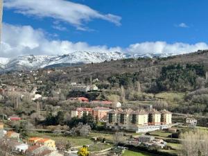 a city with snow covered mountains in the background at El Rinconcito de Bejar in Béjar