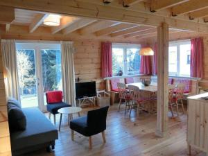 un soggiorno con tavolo e sedie di Wooden house with sauna in K stelberg a Medebach