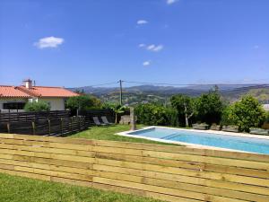 a backyard with a wooden fence and a swimming pool at Casas do Paço - Casas de Férias in Cabeceiras de Basto