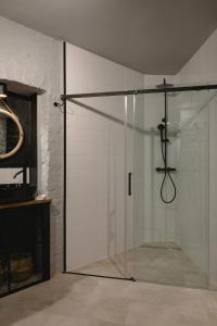 een douche met een glazen deur in de badkamer bij City Garage Apartment - Lwowska 9 in Warschau