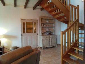 a living room with a staircase and a couch at Les Merisiers in Le Pin-la-Garenne +20 photos