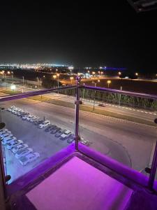 a view of a city at night with purple lights at أمواج للشقق المخدومة - FoR SERVICED APARTMENTS in Al Jubail