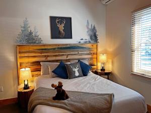 a teddy bear sitting on a bed in a bedroom at Enchantment Lodges - 5 min walk to downtown in Leavenworth