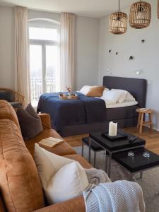 een woonkamer met een bed en een bank bij Wohlfühl-Apartment am Lösnitzgrund in Radebeul