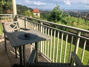 uma mesa com um chapéu em cima de uma varanda em Wohlfühl-Apartment am Lösnitzgrund em Radebeul