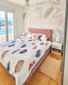 een slaapkamer met een groot bed met een roze hoofdeinde bij Apartment Atria II in Vrnjačka Banja