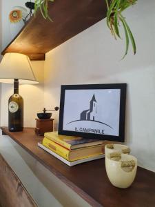 ein Regal mit Büchern, einer Uhr und einer Lampe in der Unterkunft Il campanile in Laterina