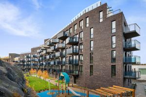 an apartment building with a playground in front of it at Scandpoint Apartments OSLO ski in ski out all year in SNOOSLO with Free Parking in Høybråten