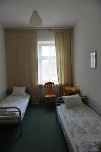 Cette chambre comprend 2 lits et une fenêtre. dans l'établissement Pokoje Gościnne Domu Pielgrzyma w Supraślu, à Supraśl