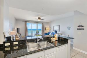 a kitchen with a sink and a view of the ocean at Calypso Resort Beachfront Condo in Panama City Beach
