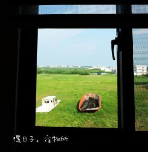 a view from a window of a field with a skateboard at 曬日子宿物所Sundays BnB 包棟民宿 in Huxi