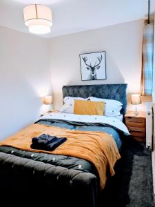 a bedroom with a large bed with a blue headboard at Crystal Suite 2 -free private parking in North Shields