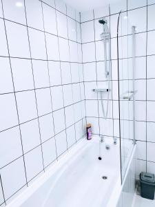 a white bathroom with a tub and a shower at Crystal Suite 2 -free private parking in North Shields