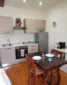a kitchen with a table and chairs and a kitchen with a stove at Il campanile in Laterina +7 photos