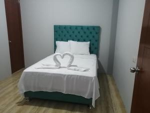 Schlafzimmer mit einem Bett mit einem grünen Kopfteil in der Unterkunft Apartamento familiar in Tarapoto
