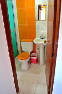 an orange bathroom with a toilet and a sink at Hotel Itzamana in Iza