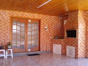 a brick wall with a wooden door in a room at Rosa dos Ventos - CASA in Urubici