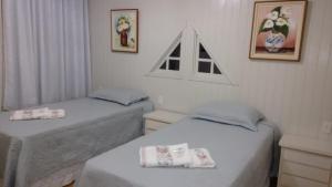 two twin beds in a room with two at Rosa dos Ventos - CASA in Urubici