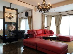 a living room with red furniture and a chandelier at BIWAKO RESORT Second House in Omihachiman