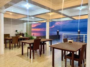 PamAnilao and Padoy's Dive Camp في باتانجاس سيتي: غرفة طعام مع طاولات وكراسي ولوحة