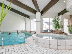 een groot zwembad met twee personen in het zwembad bij Apartment Brovst VII in Brovst