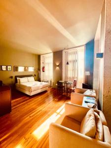 a bedroom with a couch and a bed and a table at CLUBE Charming Apartments - Cedofeita in Porto