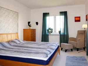 1 dormitorio con 1 cama, 1 silla y 1 ventana en Holiday home GAMLEBY V, en Gamleby