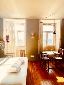 波多的住宿－CLUBE Charming Apartments - Cedofeita，一间带桌子和床的卧室以及一间用餐室