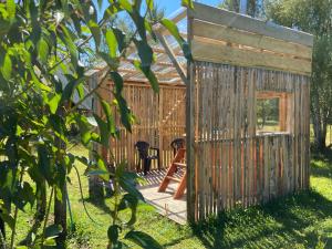 a wooden cabin with a deck in the grass at Cabañas Campestres Villarrica in Villarrica