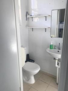 Baño blanco con aseo y lavamanos en Manly Bunkhouse en Sídney