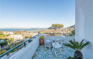 a balcony with a table and chairs and the ocean at 2 Bedroom Nice Apartment In Ischia in Ischia