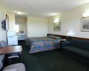 Habitación de hotel con cama y sofá en High Desert Motel Joshua Tree National Park, en Joshua Tree