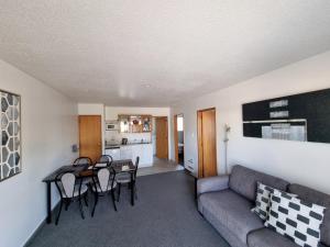 ASURE Highpark Motor Inn في غرايموث: غرفة معيشة مع أريكة وطاولة وكراسي