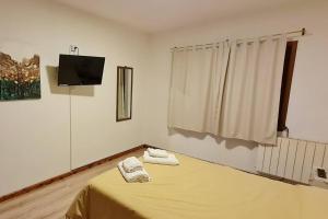 ein Zimmer mit einem Bett mit zwei Handtüchern darauf in der Unterkunft Alpenhaus - Cálido depto céntrico 5 pax - con estacionamiento in San Carlos de Bariloche