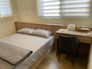 1 dormitorio con cama, escritorio y silla en Shiny Homestay en Magong