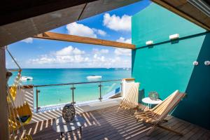 a balcony with chairs and a view of the ocean at MOJITO in Grand Case