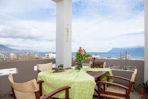 een tafel en stoelen op een balkon met uitzicht op de oceaan bij Castel View Experience in Kissamos