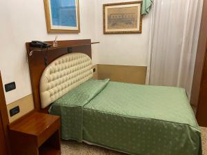 a small bedroom with a bed and a table at Atlantide Hotel in Venice